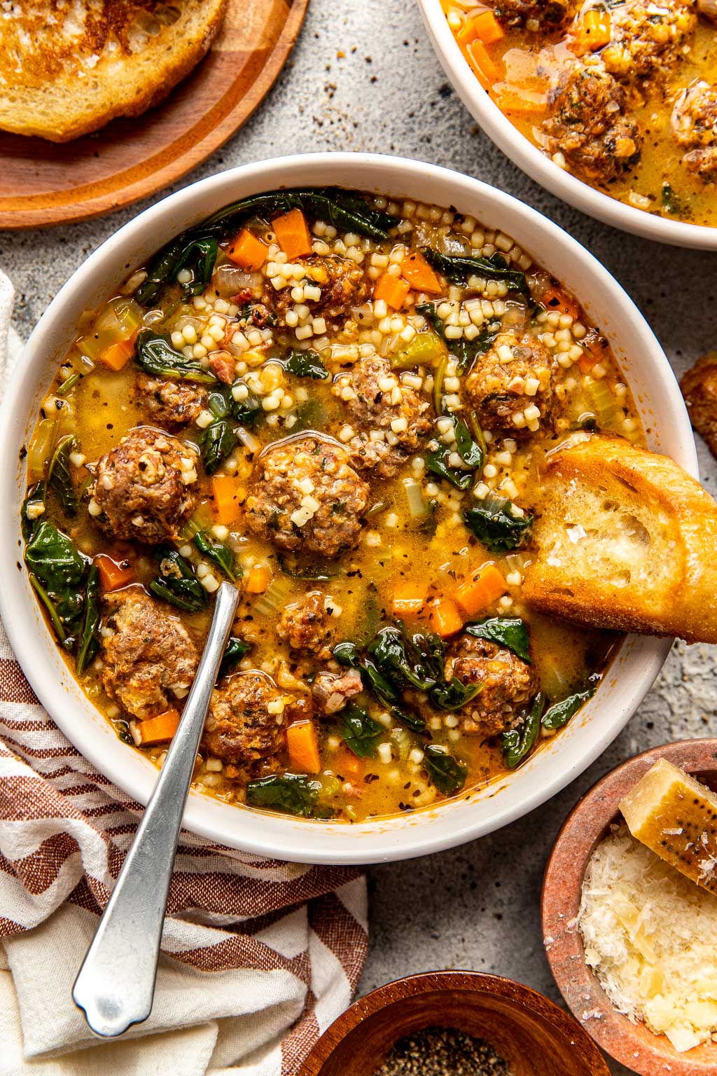 A bowl of Italian wedding soup with mini meatballs 