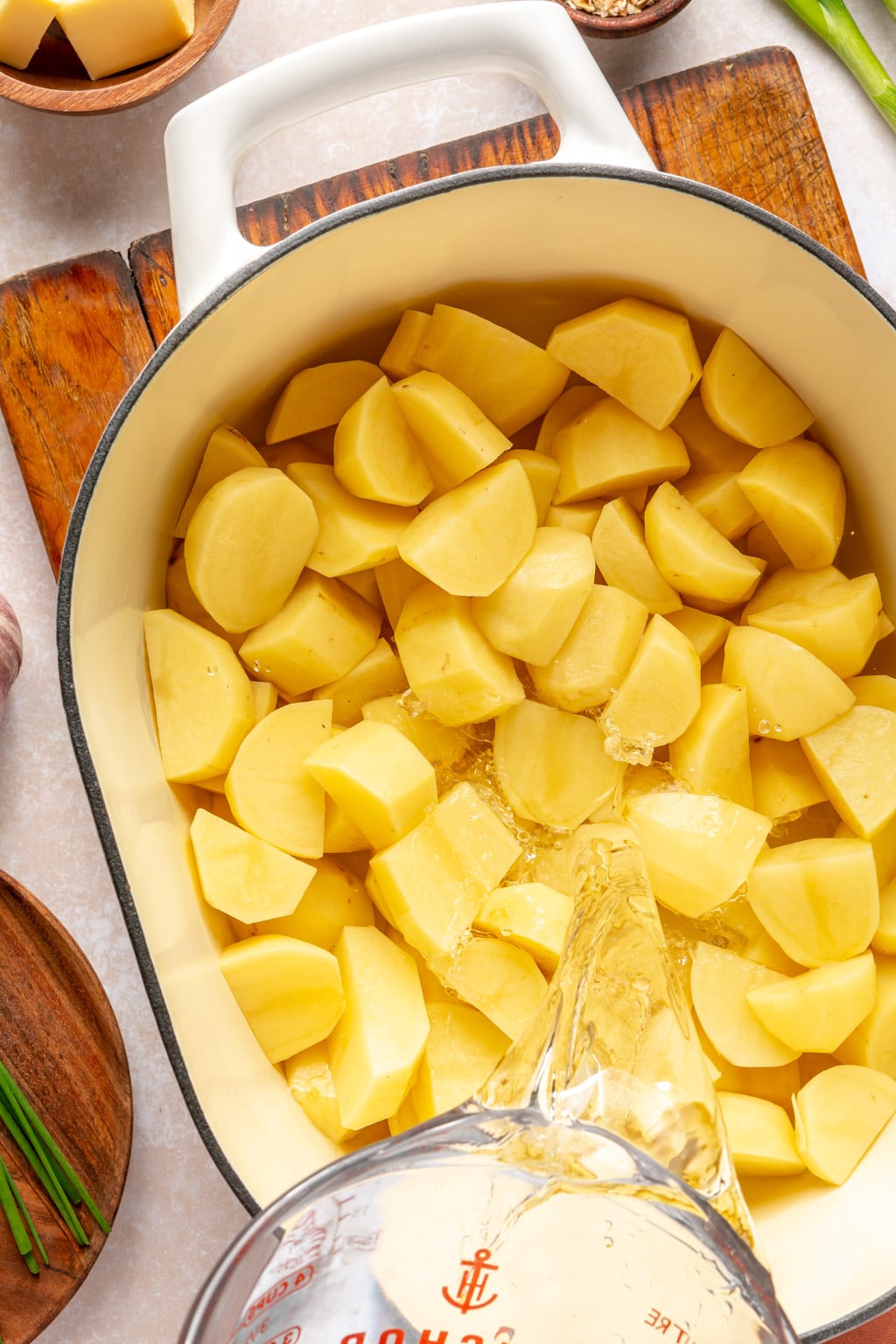 Cut potatoes being covered with water 