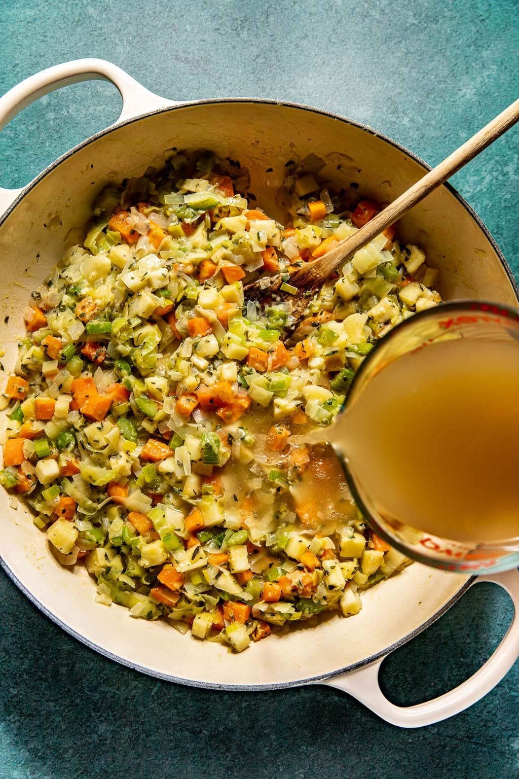 Chicken stock being added to pot pie filling 