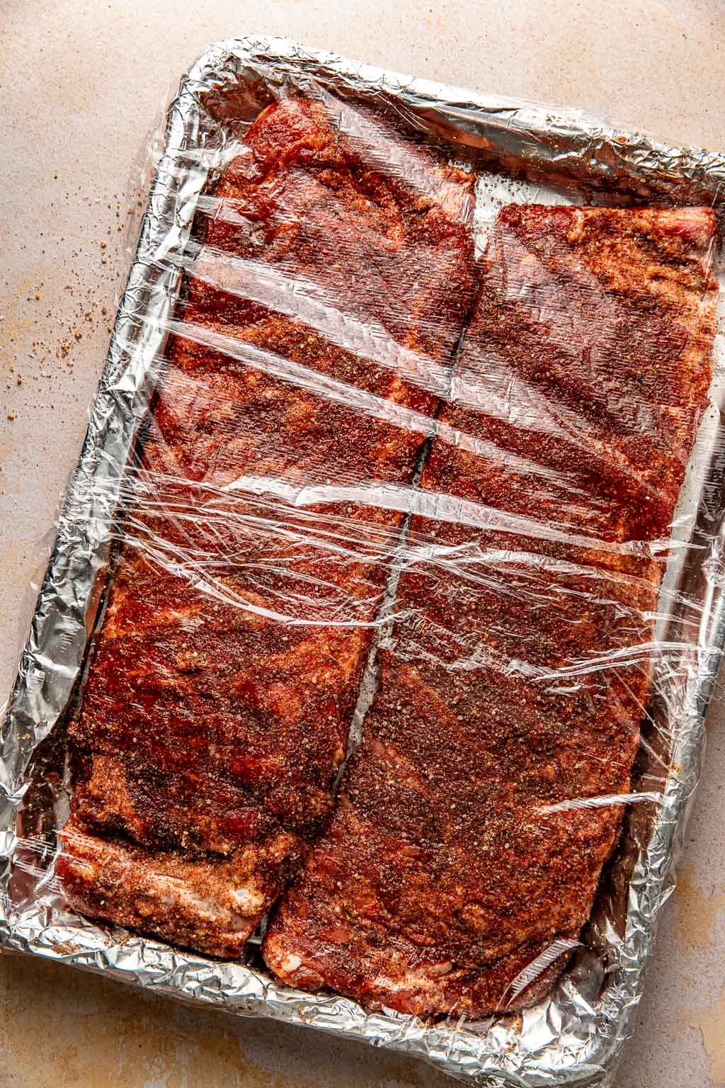 ribs sitting on a baking sheet with the rub