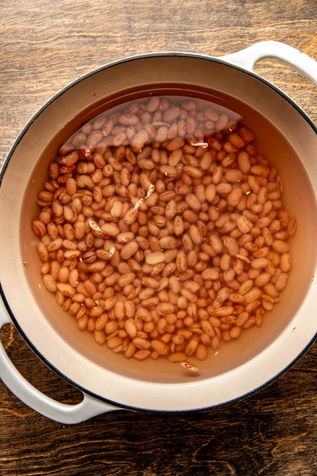 dried beans in a dutch oven soaking in water