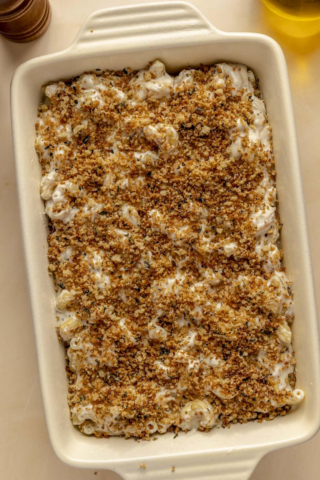Mac and cheese topped with breadcrumbs, ready to be baked. 