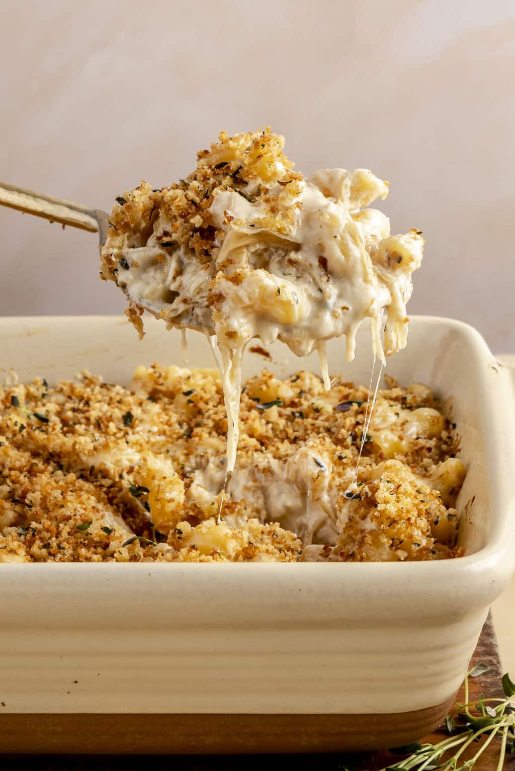 A spoonful of baked French onion mac and cheese held aloft. 
