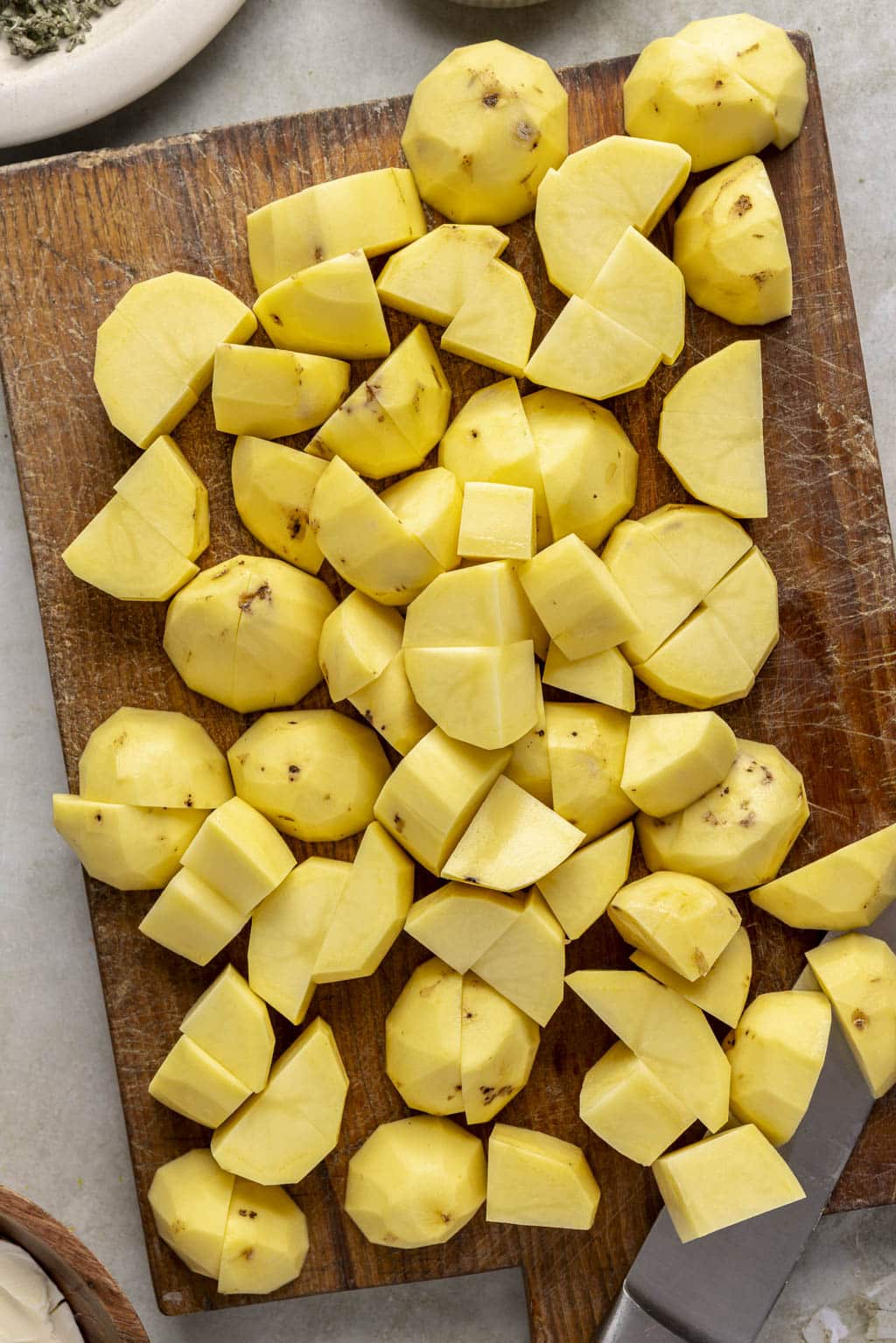 Cut potatoes on a cutting board. 