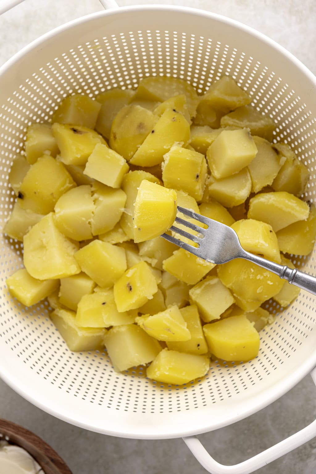 Fork tender potatoes in colander. 