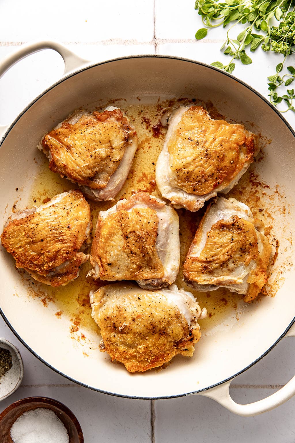 crispy, skin side-up chicken thighs in a braising pan