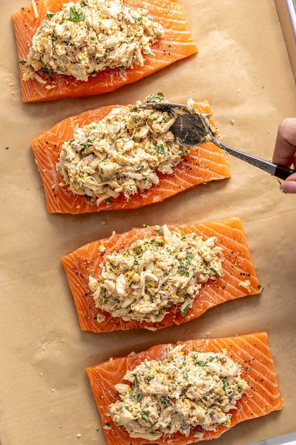 stuffing salmon with crab mixture on a baking sheet