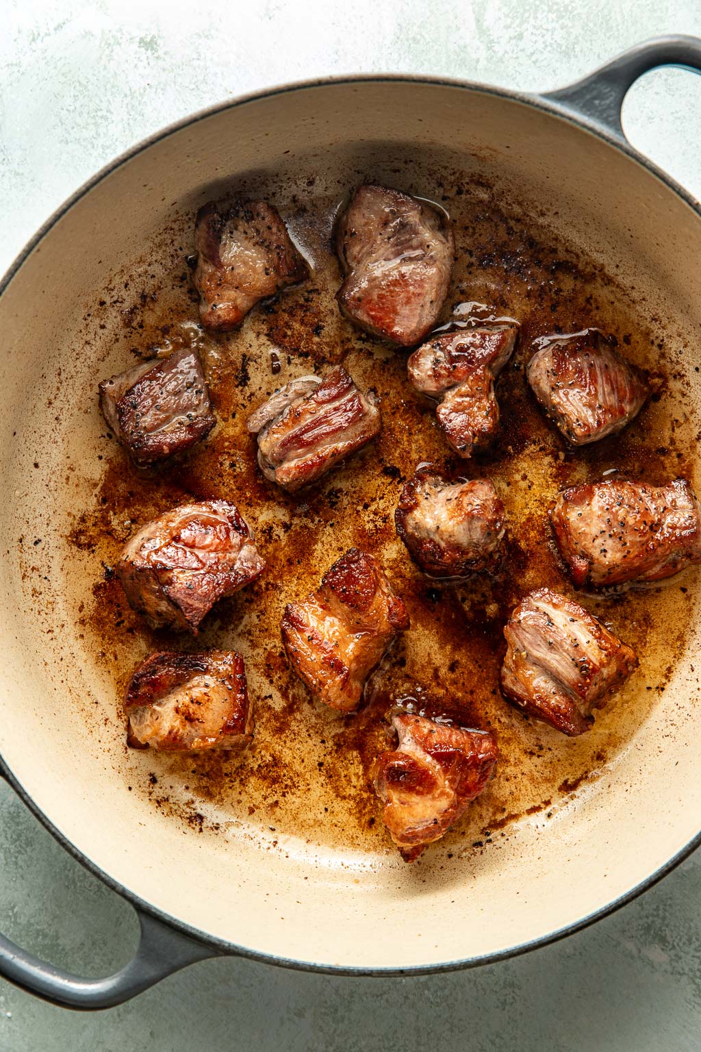 pork being seared in a large dutch oven
