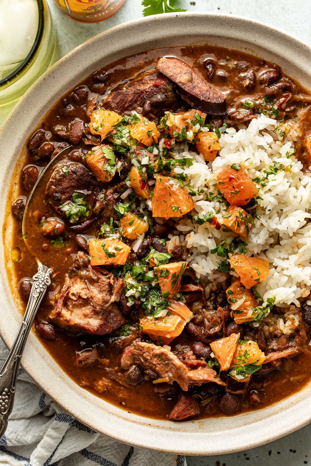 feijoada in a bowl with rice and orange chimichurri