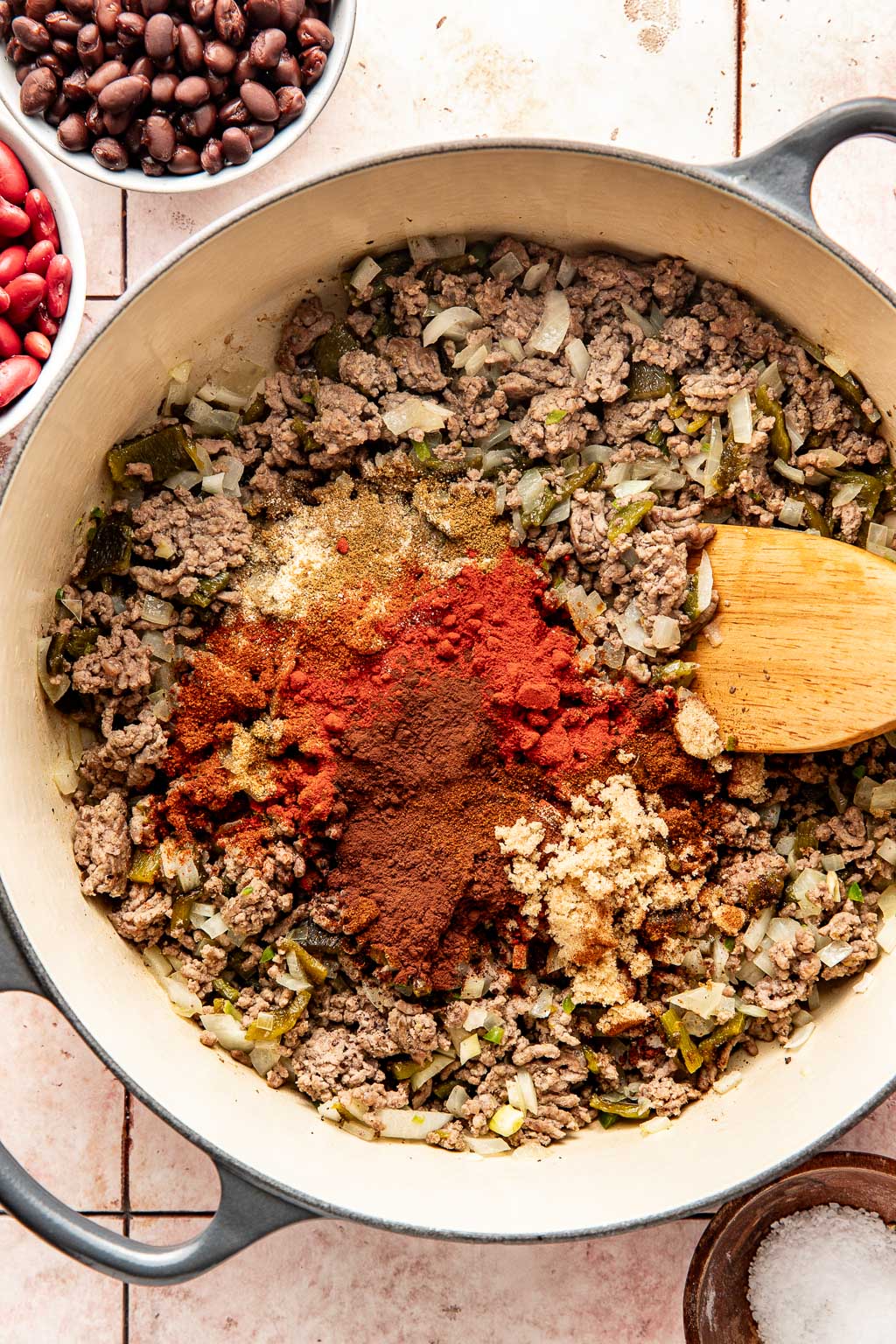 spices being added to the ground beef and peppers