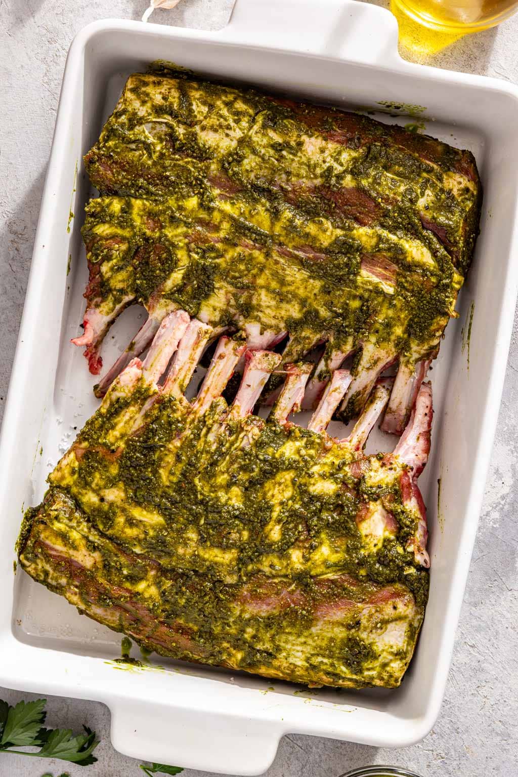 racks of lamb marinating in a baking dish