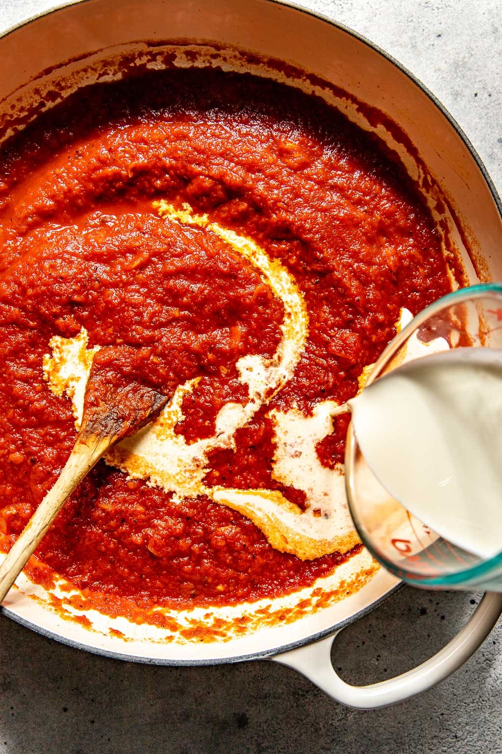 Cream being added to the vodka sauce