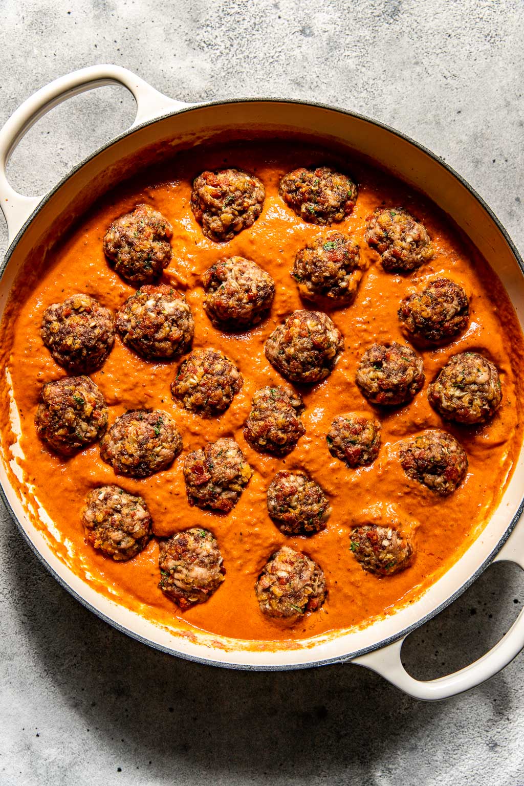 Meatballs in a braiser in vodka sauce before simmering