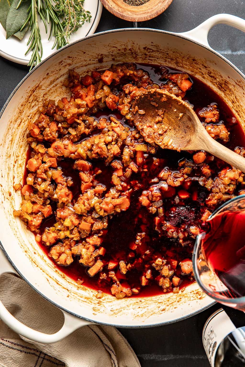 red wine being poured into the braiser